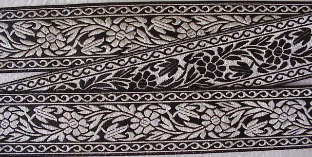 Jacquard ribbon trim. Metallic silver flowers on a black background.